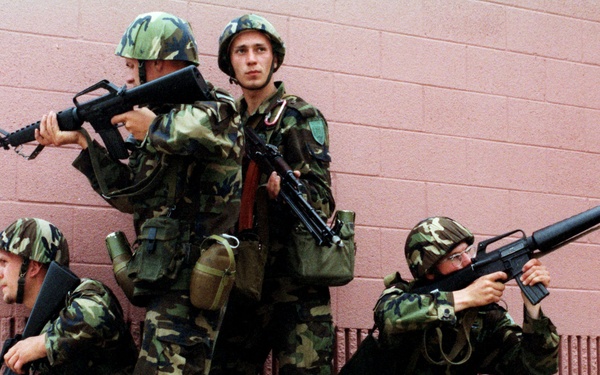 Four Latvian soldiers keep a sharp look out in the Military Operations in Urban Terrain facility.