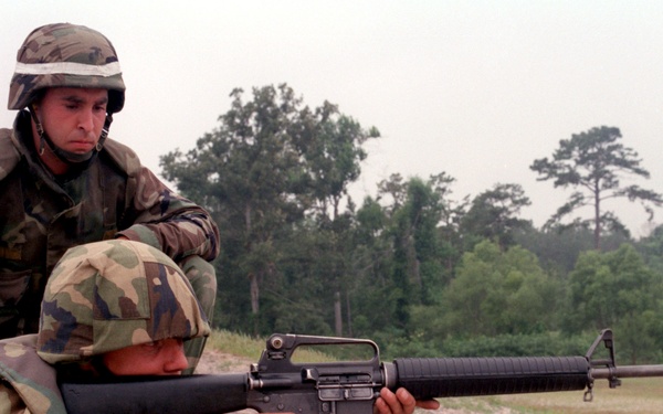 U.S. Marine Cpl. Mark instructs a Latvian soldier on firing an M-16A2 service rifle.