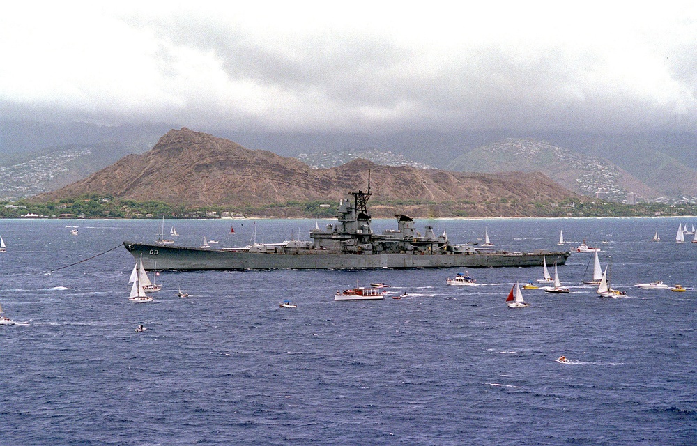 The battleship USS Missouri (BB 63) is towed past Diamond Head en route to Pearl Harbor.