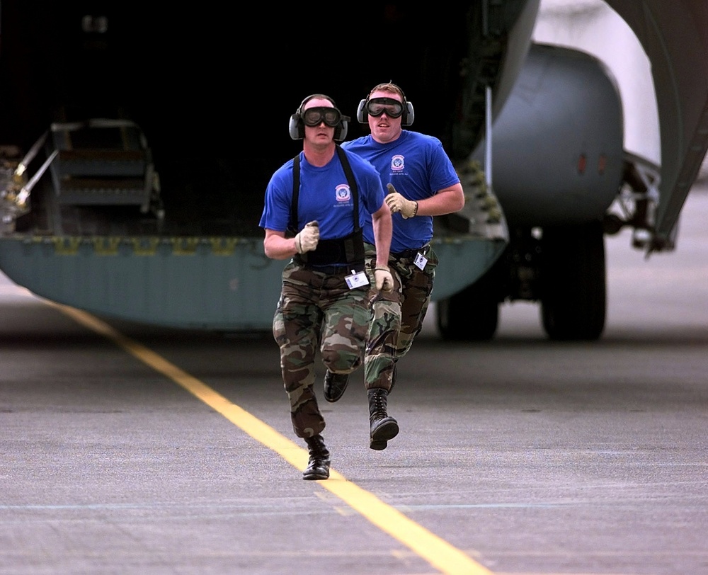 Tech. Sgt. Wenn and Senior Airman Larson run from the back of a C-141 Starlifter at Rodeo 98.