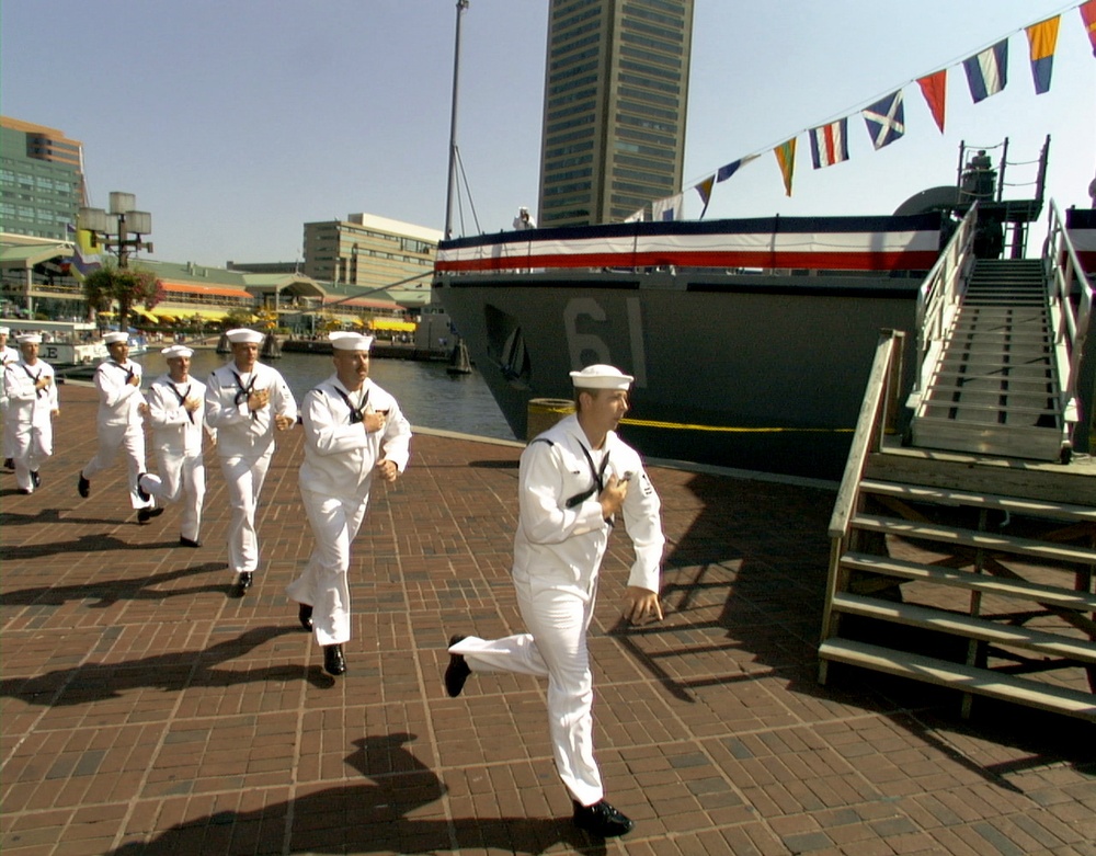 Crew members run on board to bring the USS Raven (MHC 61) to life in Baltimore.
