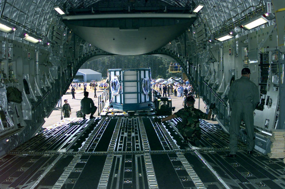 A C-17 loadmaster positions a cargo loader in preparation for loading Keiko, the killer whale