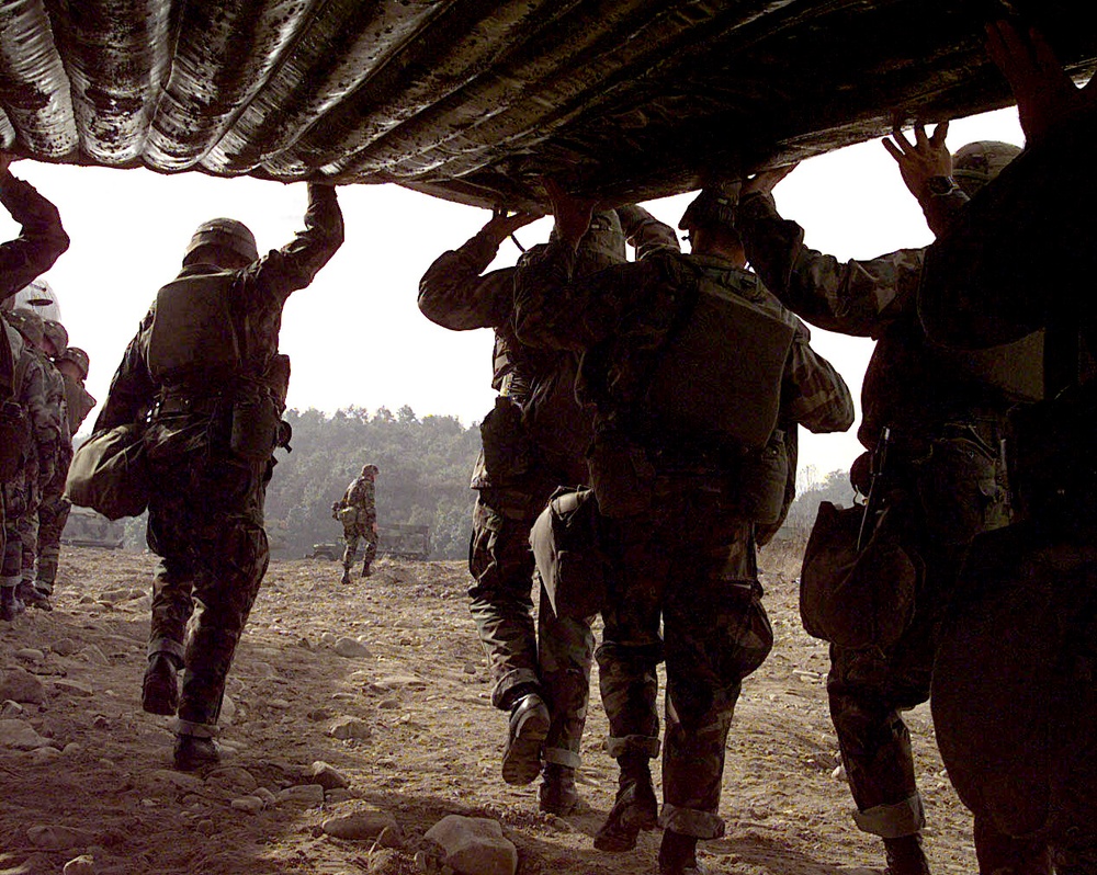 Soldiers team up to carry a rubber raft to the edge of the Imjin River in the Republic of Korea.