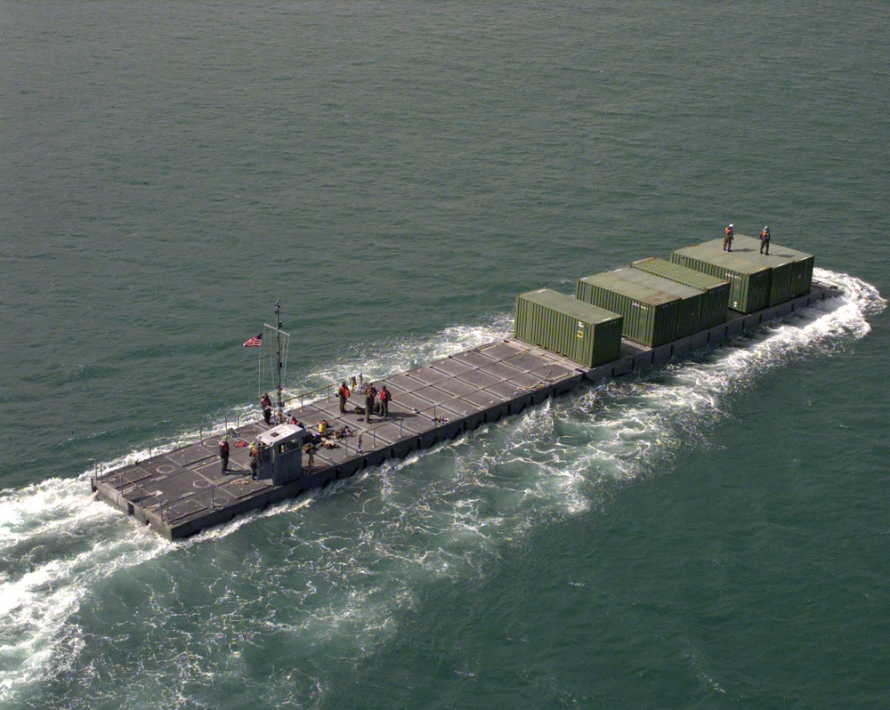 A U.S. Army Modular Causeway System transports equipment from the USNS Pollux.