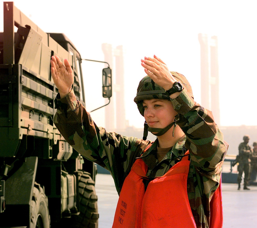Spec. Daphne Wright directs the flow of vehicles being off loaded at the port of Pyongtaek.