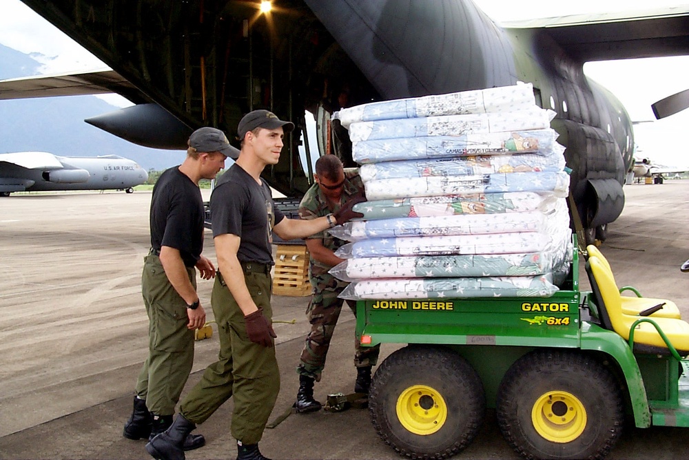 U.S. and Canadian service men unload mattresses and relief supplies for victims of Hurricane Mitch.