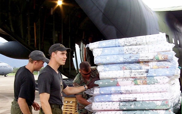 U.S. and Canadian service men unload mattresses and relief supplies for victims of Hurricane Mitch.