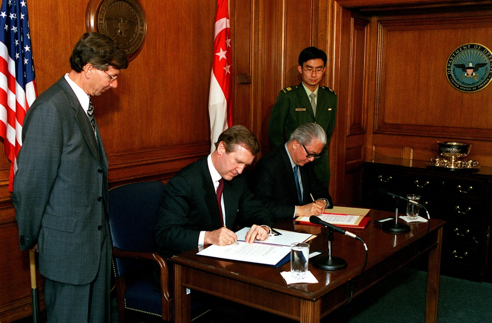 Secretary Cohen and Deputy Prime Minister Tan sign a document in the Pentagon.