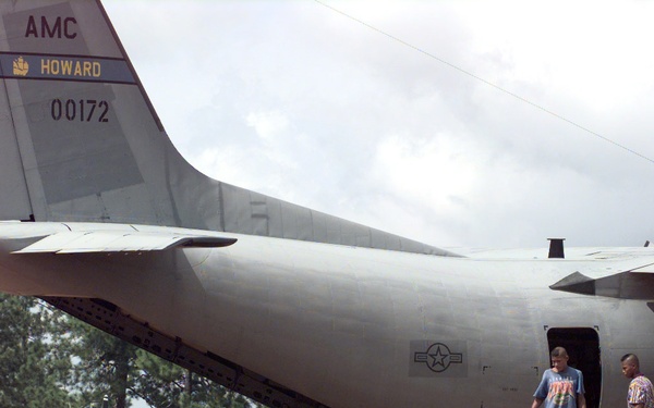 Members of the Honduran military and civilian volunteers help sort a pile of disaster relief supplies.