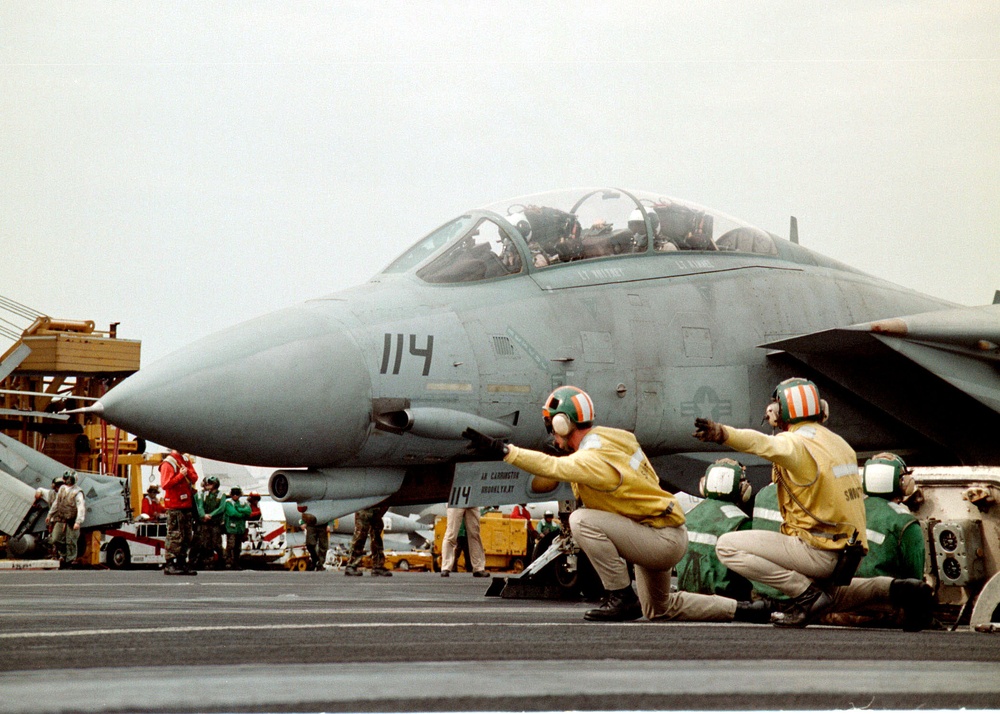 A Navy F-14B Tomcat is given the signal to launch from the flight deck of the USS Enterprise.