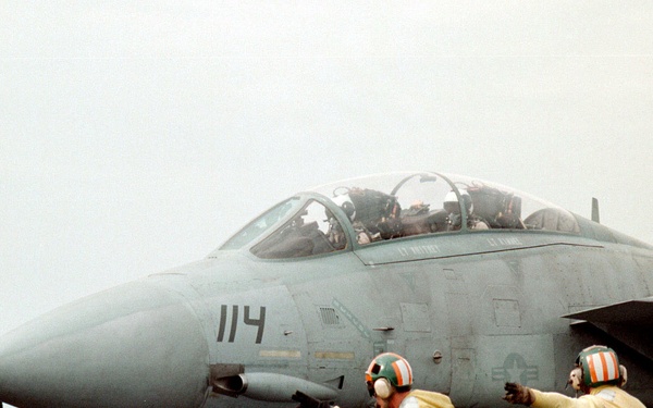 A Navy F-14B Tomcat is given the signal to launch from the flight deck of the USS Enterprise.