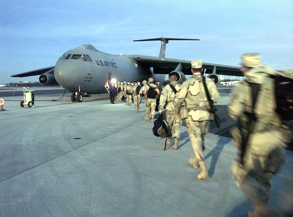 Members of the 437th Security Forces Squadron board a C-141 for the Persian Gulf region.