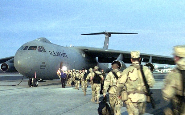 Members of the 437th Security Forces Squadron board a C-141 for the Persian Gulf region.