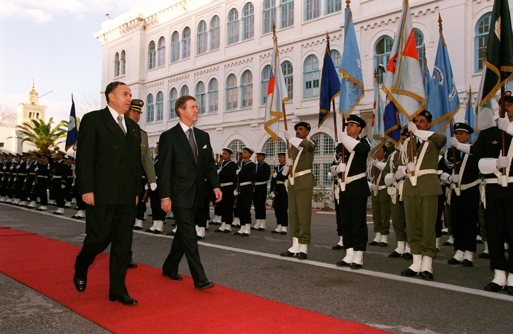 Minister Habib Ben Yahia escorts Secretary Cohen at a ceremony in Tunis, Tunisia.