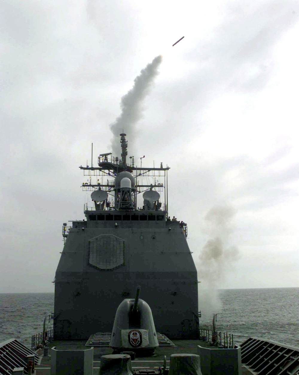 USS Philippine Sea launches a Tomahawk cruise missile in the daylight.