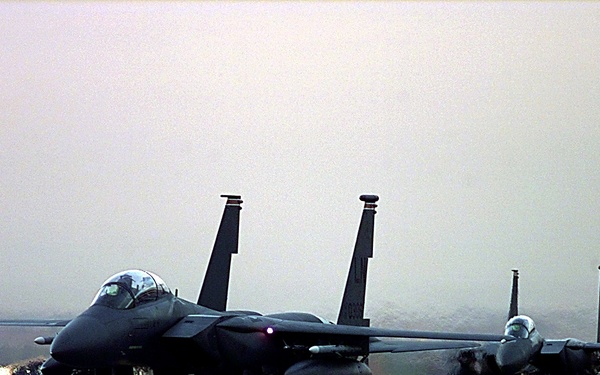 Two F-15E Strike Eagles taxi to the ramp after a mission for NATO Operation Allied Force.