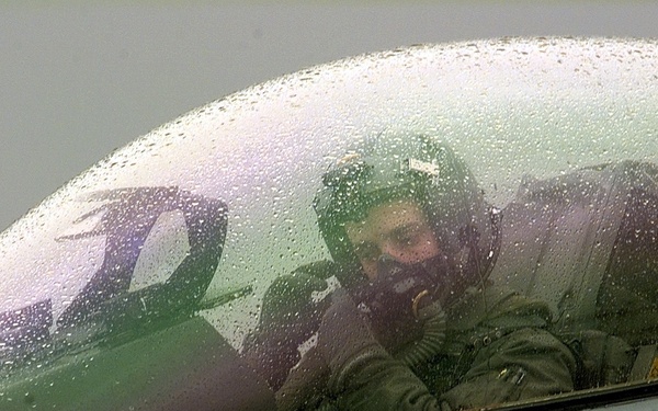 A U.S. Air Force F-16 pilot adjusts his oxygen mask as he prepares to take off from Aviano.