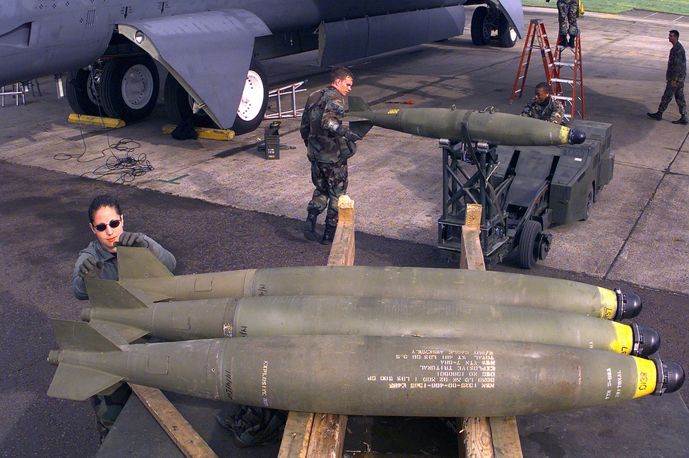 Airman 1st Class Lillian Smith rolls a Mk-82 bomb to the end of the bomb trailer.