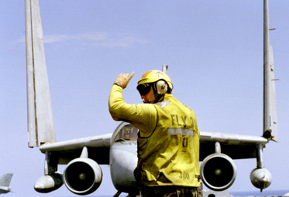 The Fly 3 Petty Officer directs an S-3B Viking on the flight deck of the USS Theodore Roosevelt.