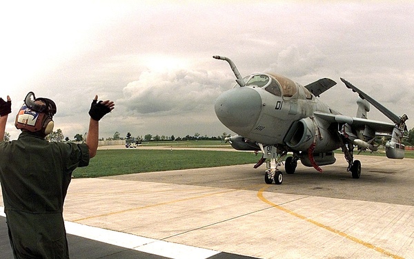 Cpl. James Bivins directs a Marine EA-6B Prowler to a spot on the ramp at Aviano Air Base.