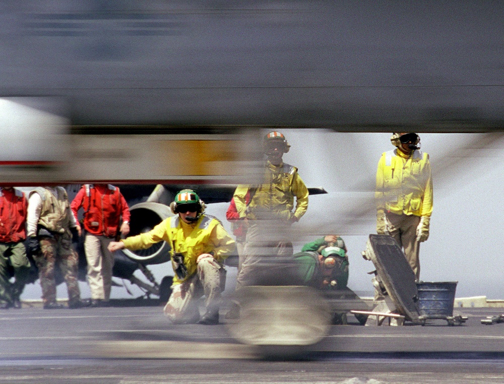 An F/A-18 Hornet becomes a blur as it is catapulted from the USS Kitty Hawk.