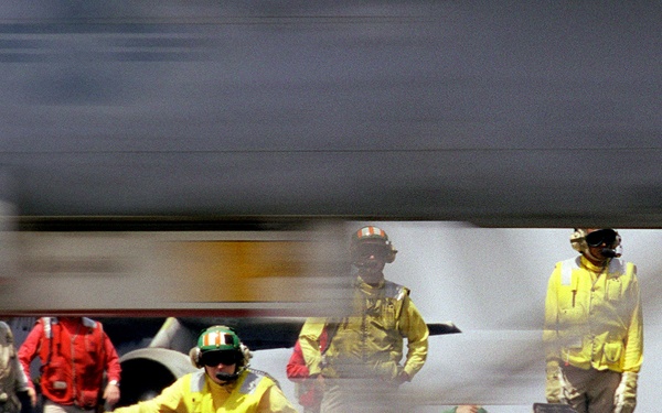 An F/A-18 Hornet becomes a blur as it is catapulted from the USS Kitty Hawk.