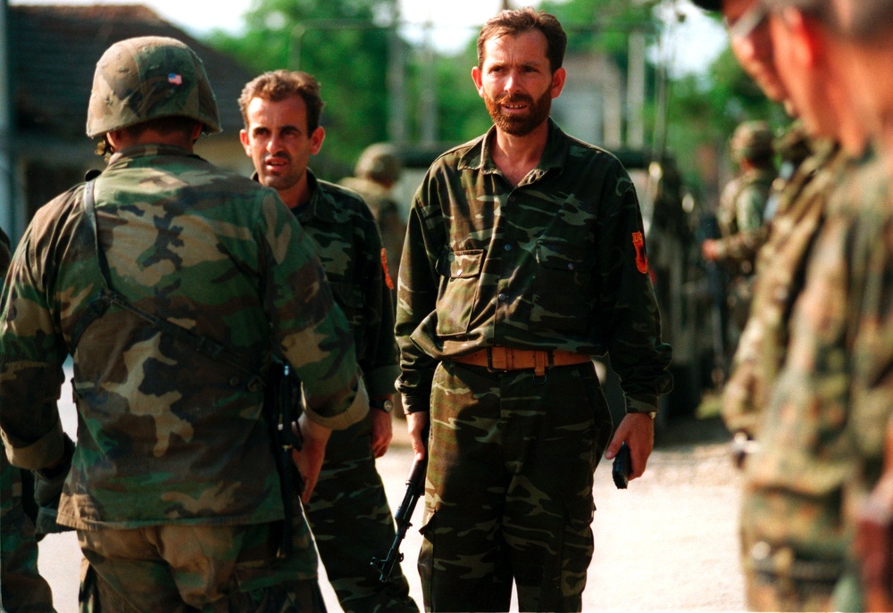 Members of the Kosovo Liberation Army stand in formation to turn over their weapons to U.S. Marines.