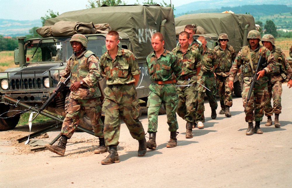 U.S. Marines escort Serbian detainees to the Kosovo-Serbian border.