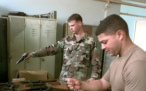 Staff Sgts. Rivera and Casey clear and safe weapons and ammunition that were confiscated.
