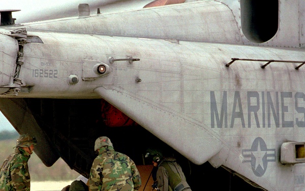 U.S. Marines wrestle a pallet of bottled water out of a CH-53E Super Stallion at the Turkish Naval Base.