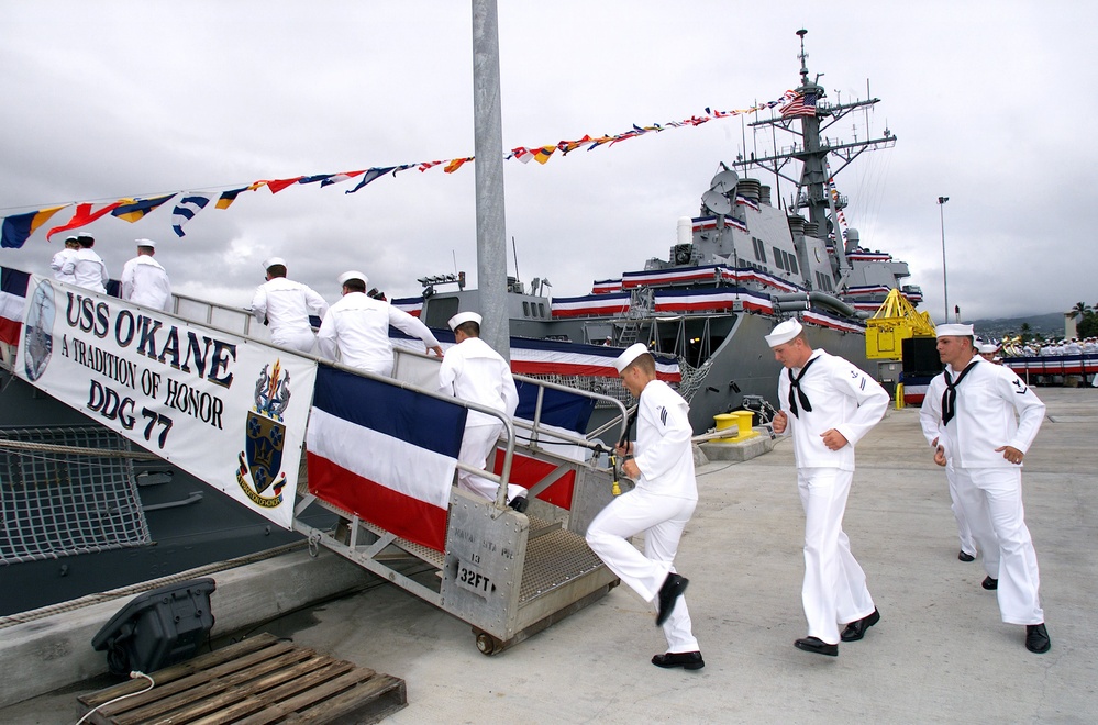 Crew members of the USS O'Kane run aboard to bring the ship to life during the ship's commissioning.