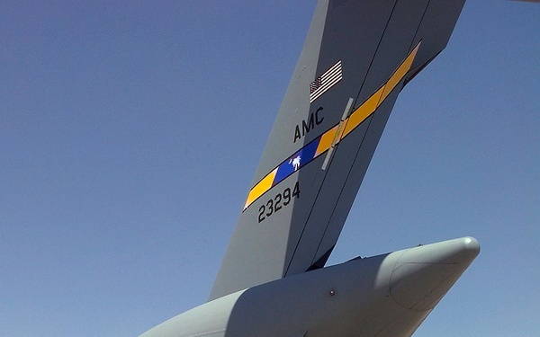 A crew member of a C-17 Globemaster III directs a fork lift operator as equipment and personnel are unloaded at Cairo West.