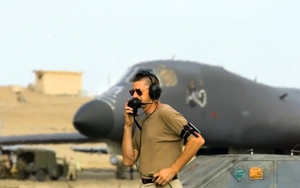 A B-1B Lancer bomber crew chief talks to the air crew in the plane on the flight line at Cairo West Air Base, Egypt.