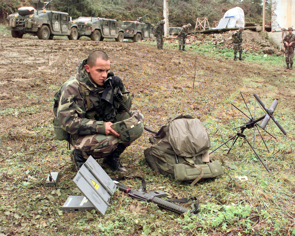 Cpl. Carlos Rivera uses a satellite phone to establish communications from the village of Skugrici, Bosnia and Herzegovina.