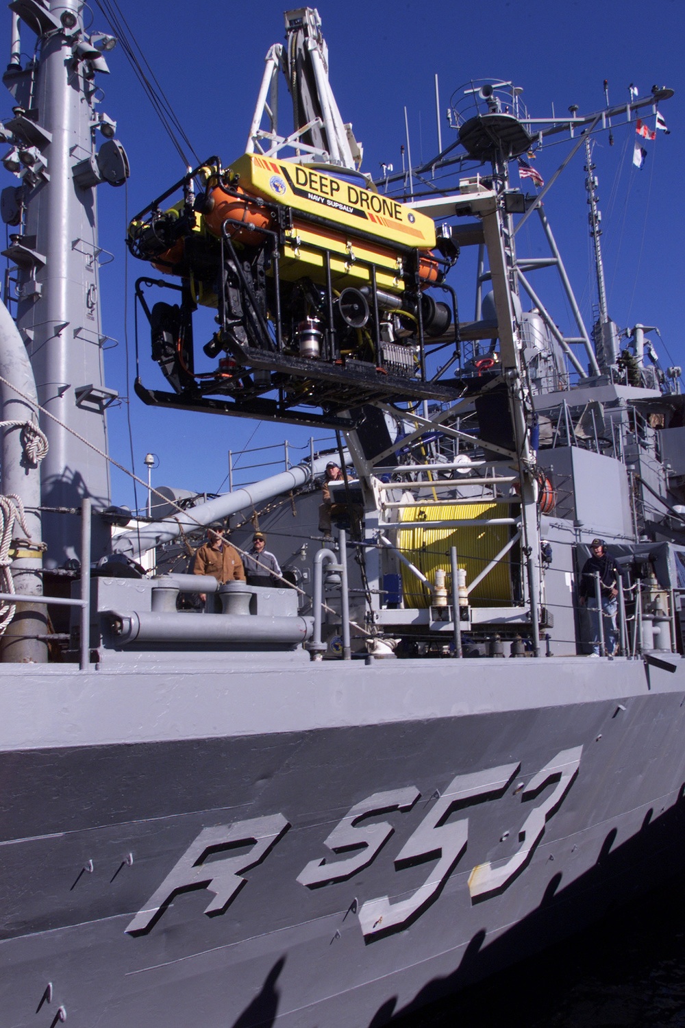 Crew members of the USS Grapple lower the Deep Diving Submersible Drone into the water at Naval Station Newport, R.I.