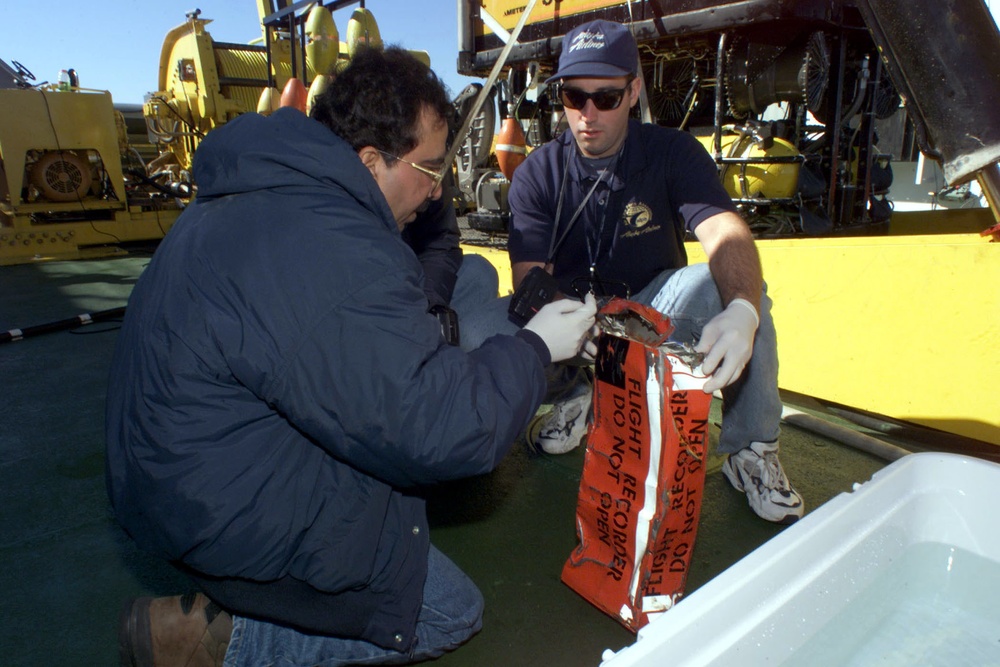Deepak Joshi and John Scarola prepare the flight data recorder from Alaska Airlines Flight 261 for transport from the MV Kellie Chouest.
