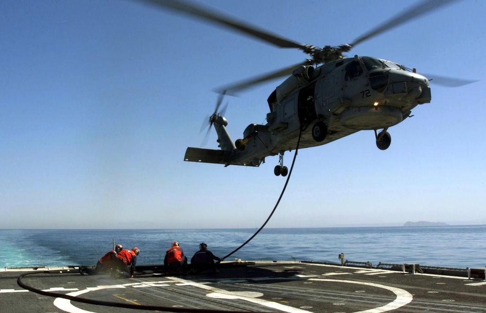 Sailors and aircrew attached to Light Helicopter Anti-Submarine Squadron 47 conduct hot-in-flight refueling of a SH-60B Seahawk helicopter.