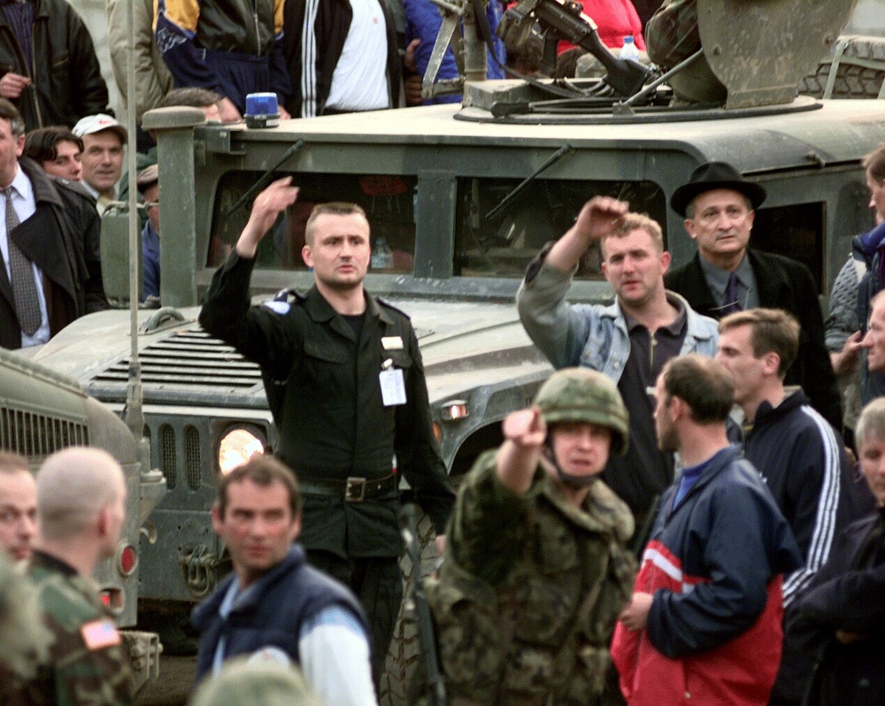 Soldiers from the 709th Military Police Battalion in Humvee's make their way through a hostile crowd in Sevce, Kosovo.