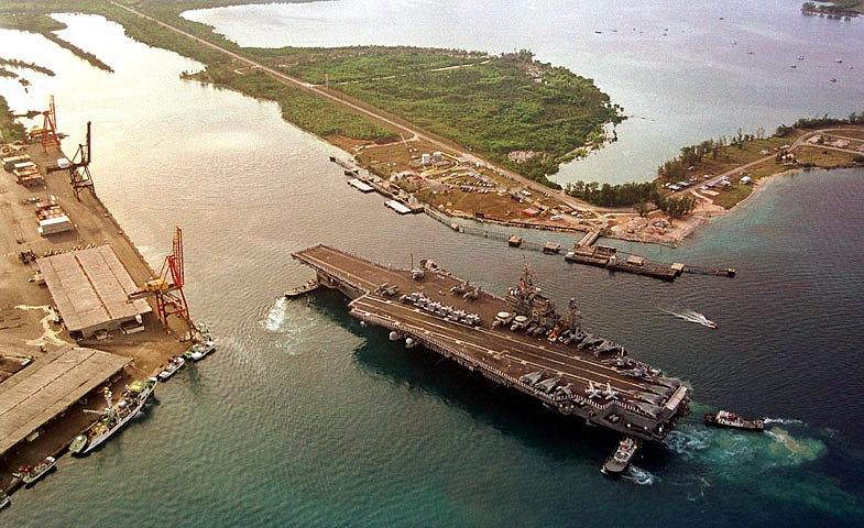 Sailors aboard the USS Kitty Hawk man the rails as the aircraft carrier pulls into Apra Harbor, Guam.