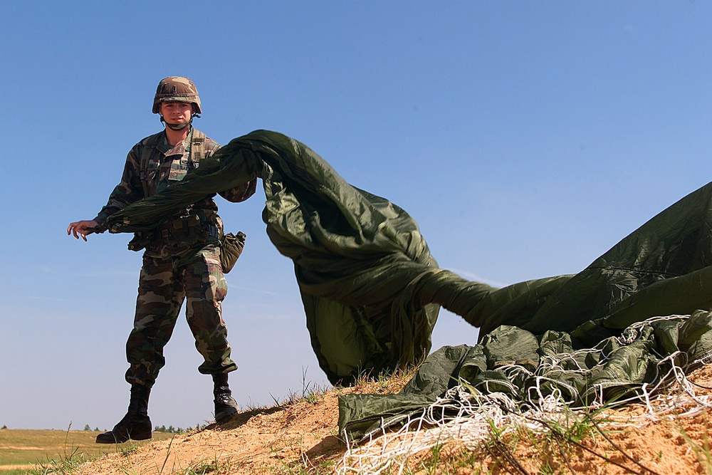 1st Lt. Kenny Hamilton recovers his parachute after jumping from a C-130 Hercules onto the Sicily drop zone at Fort Bragg.