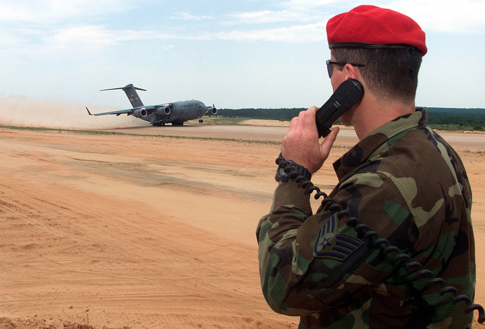 Staff Sgt. McMenamin relays wind speed to a C-17 Globemaster III as it makes an assault landing at the Holland Landing Zone.