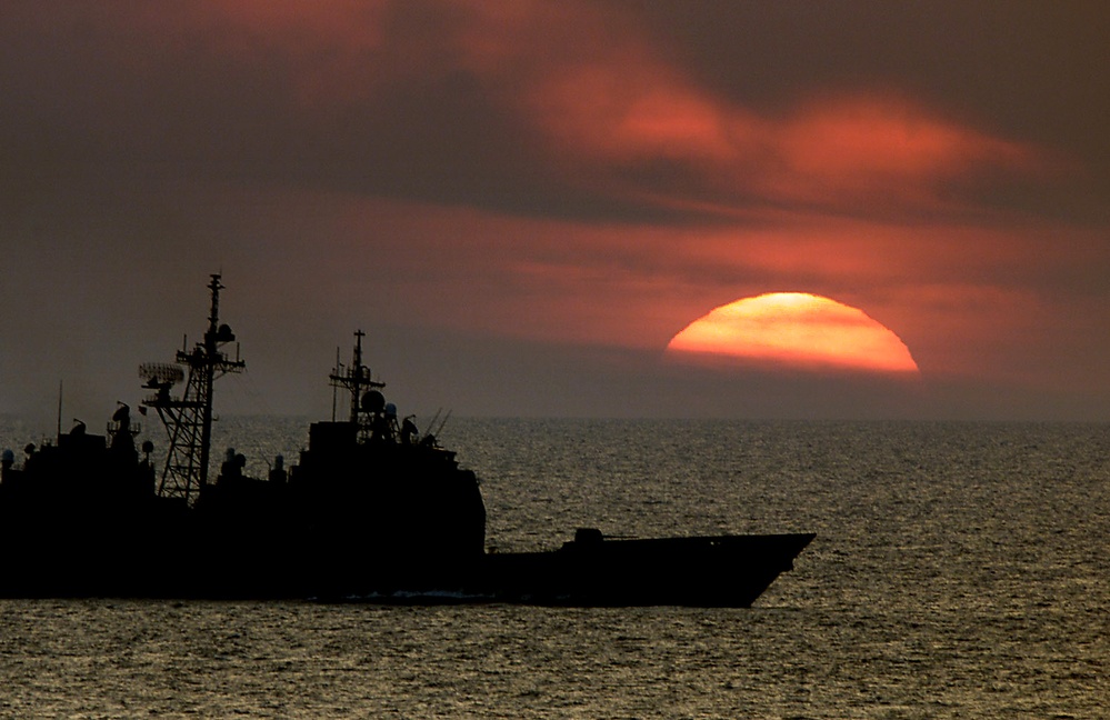 USS Normandy steams at sunset in the Atlantic while operating with the USS George Washington battle group.