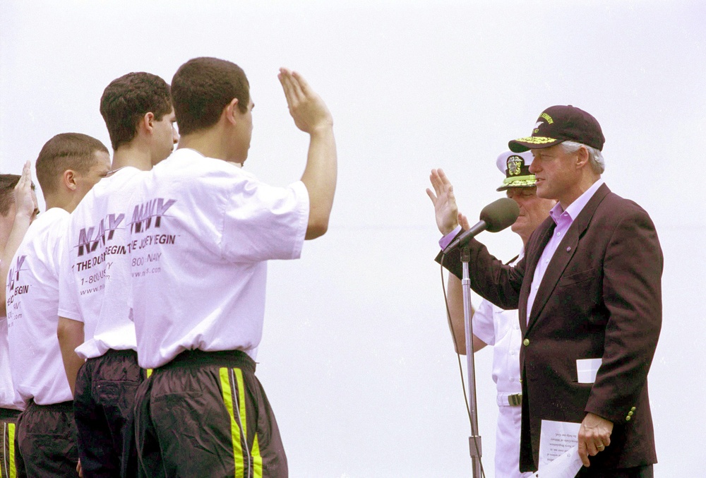 President Clinton administers the oath of enlistment to new Navy recruits in a special ceremony on board the USS John F. Kennedy.
