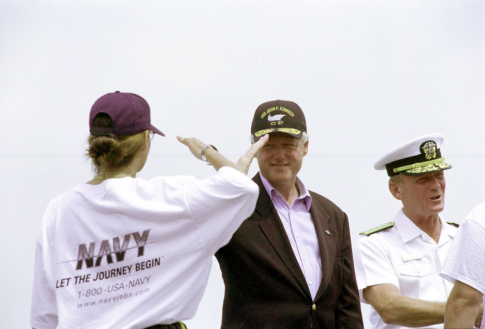 President Clinton happily salutes a newly enlisted sailor following a special enlistment ceremony on board the USS John F. Kennedy.