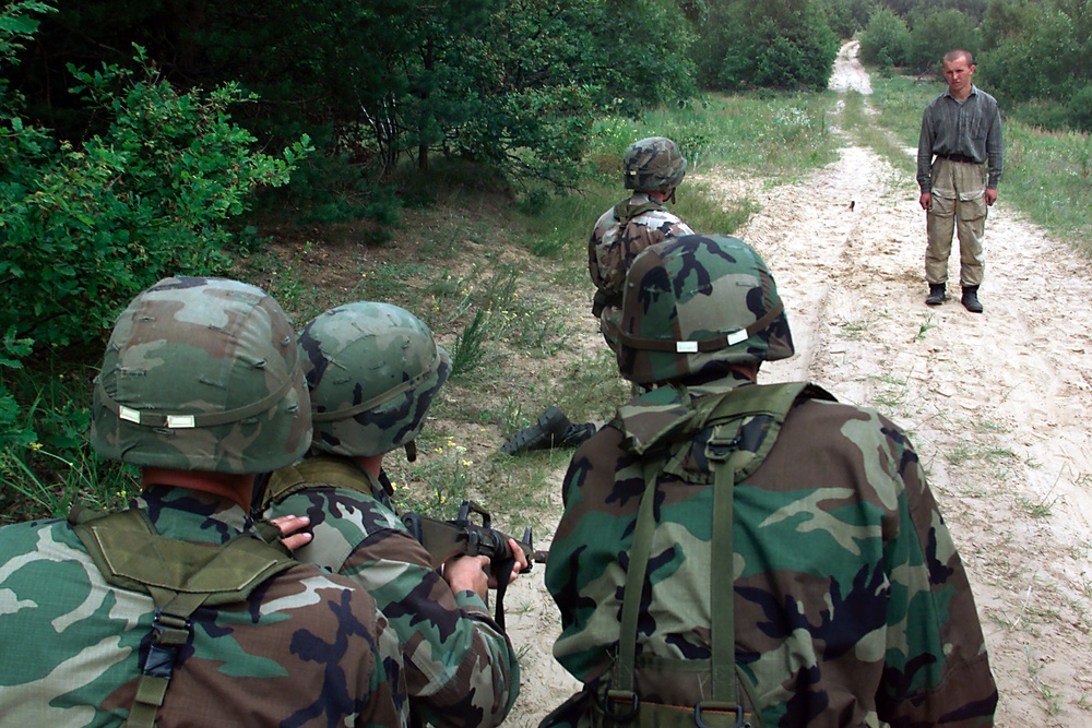 Soldiers from Bravo Company, 2nd Battalion, 130th Infantry, Illinois Army National Guard negotiate with a role-playing inebriated woodsman.