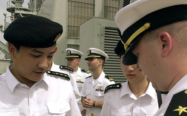 Lt. j.g. Bruce Sutherland gives Capt. Wen Hai Wu, of the People's Liberation Army (Navy), a U.S. Navy officer's crest.