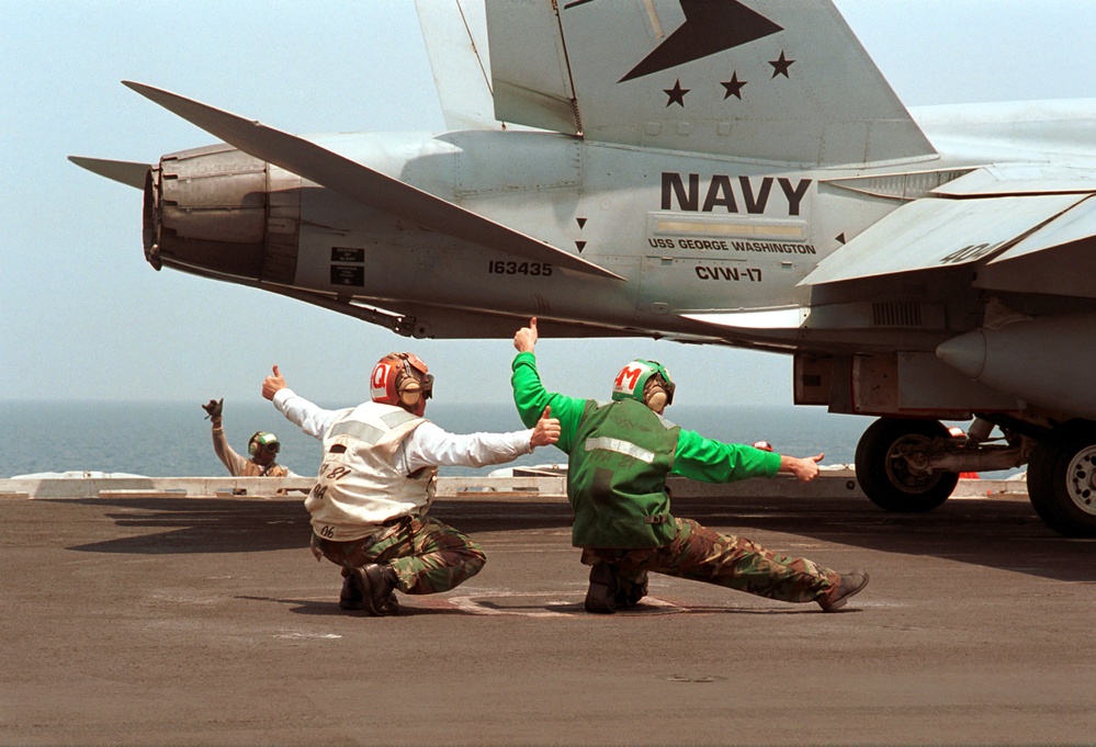 Petty Officers Curphey and Eads signal a thumbs-up for the  launch of an F/A-18C Hornet from the USS George Washington.