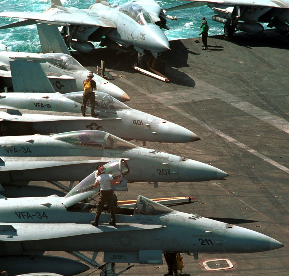 U.S. Navy plane captains clean the canopies of F/A-18 Hornets in preparation for flight operations in the Persian Gulf.