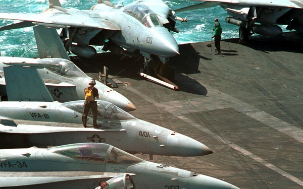 U.S. Navy plane captains clean the canopies of F/A-18 Hornets in preparation for flight operations in the Persian Gulf.