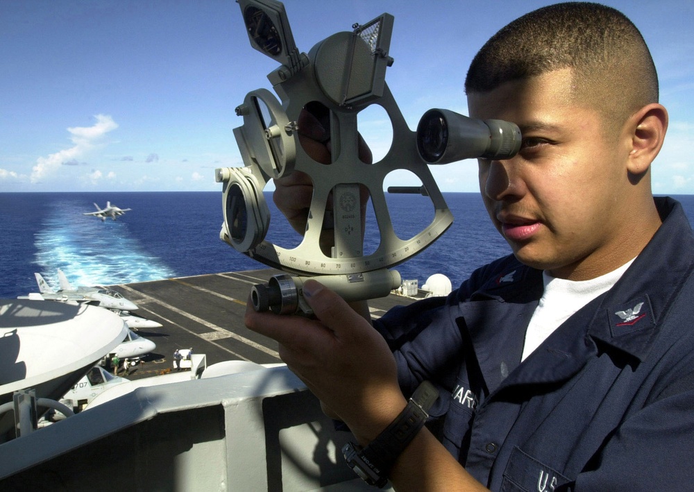 Petty Officer Alvarez uses a sextant to plot the navigational position of the USS Abraham Lincoln.